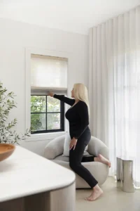Woman easily opening Wynstan honeycomb blind